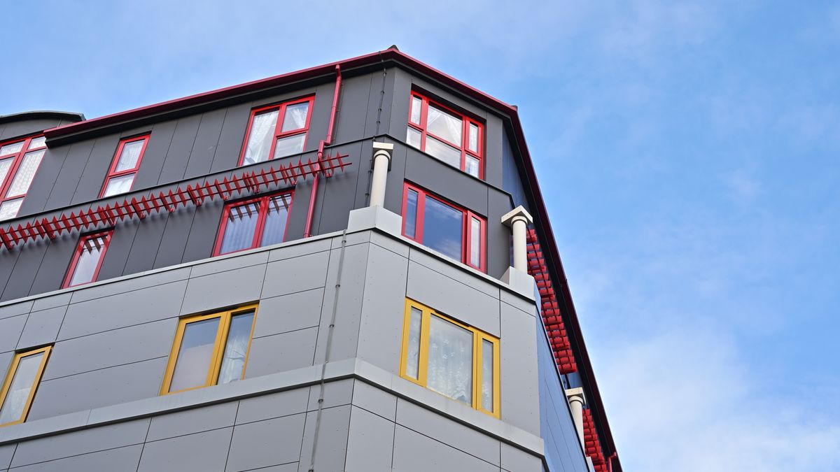 青空を背景にした投資用マンションの外観。立地条件や駅からの徒歩分数も選定基準のひとつになります。