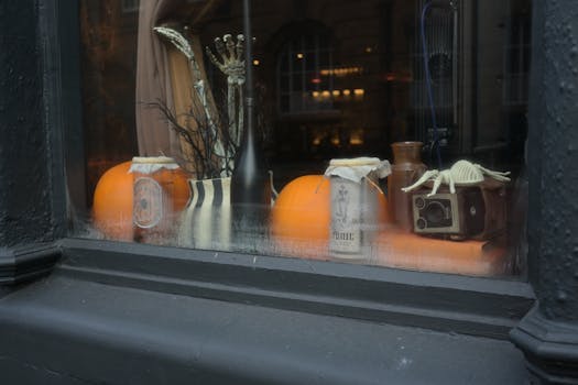 Spooky Halloween window display featuring pumpkins, skeletons, and vintage objects.