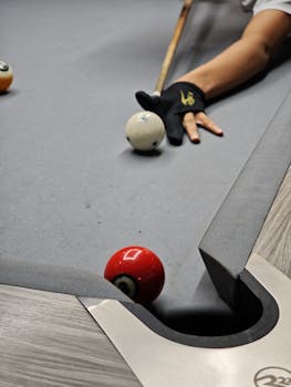 Close-up of a pool game with strategic shot in play. Perfect for articles on billiards and skill sports.