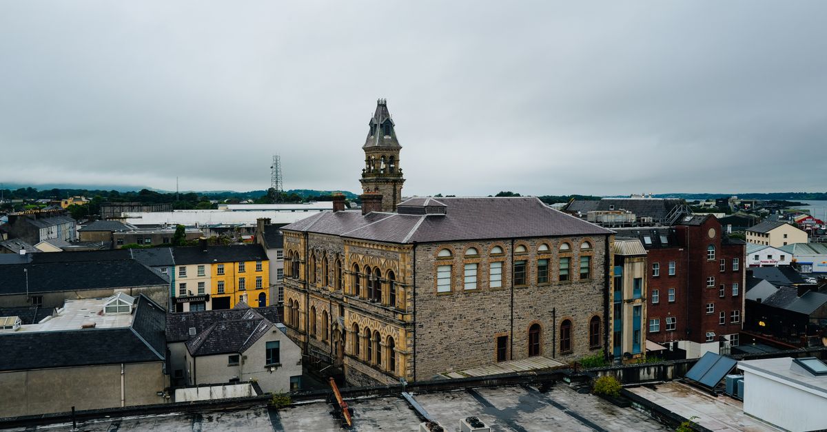 Aerial view of a historic building amidst a European cityscape under cloudy skies.