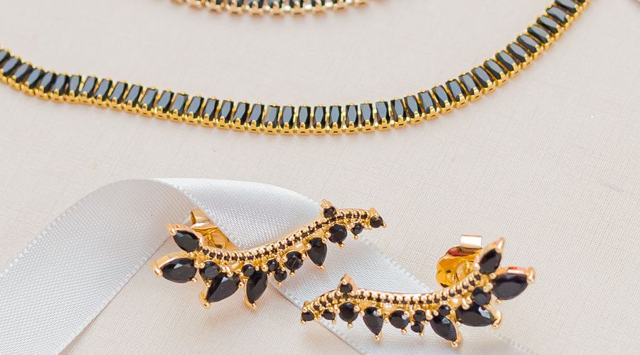 Ensemble de bijoux dorés minimalistes disposés avec élégance, idéal pour illustrer les matières à privilégier au bureau