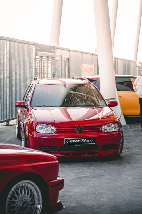 Free Bright red Volkswagen Golf showcased at a custom car event. Stylish and vibrant. Stock Photo