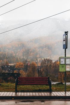 Empty bench and bus stop in misty Polish mountains during autumn.