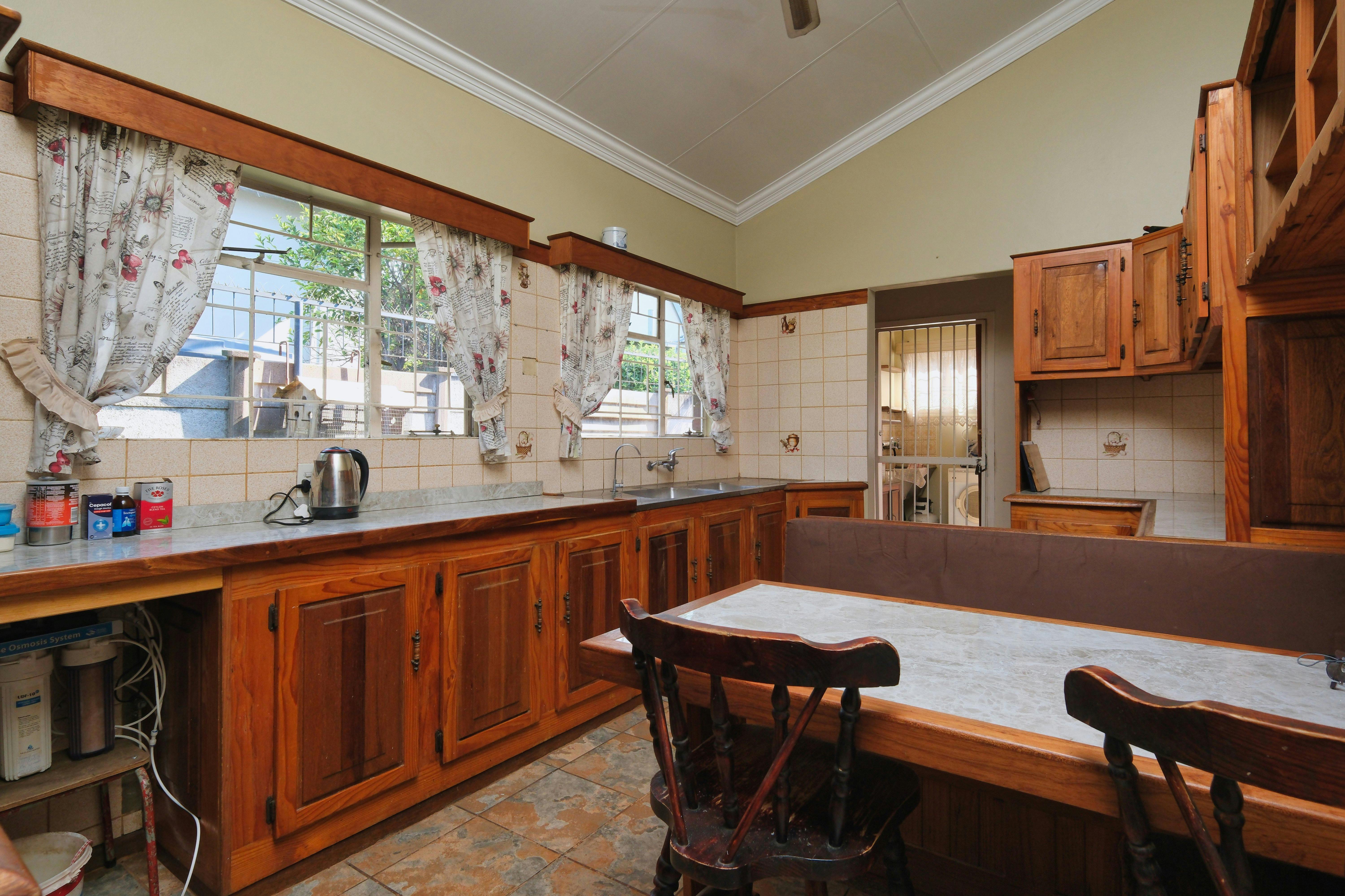A warm wooden kitchen interior with sunlight on the cabinets.