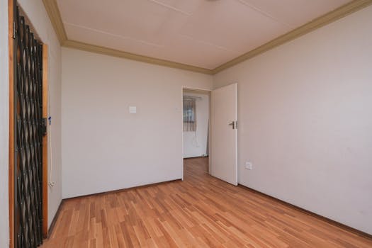 Spacious empty room featuring minimalist design and wooden flooring, perfect for real estate marketing.