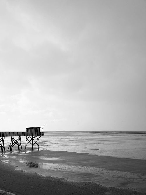 Free Black and white photo of a pier at Châtelaillon-Plage, France, showcasing a serene coastal view. Stock Photo