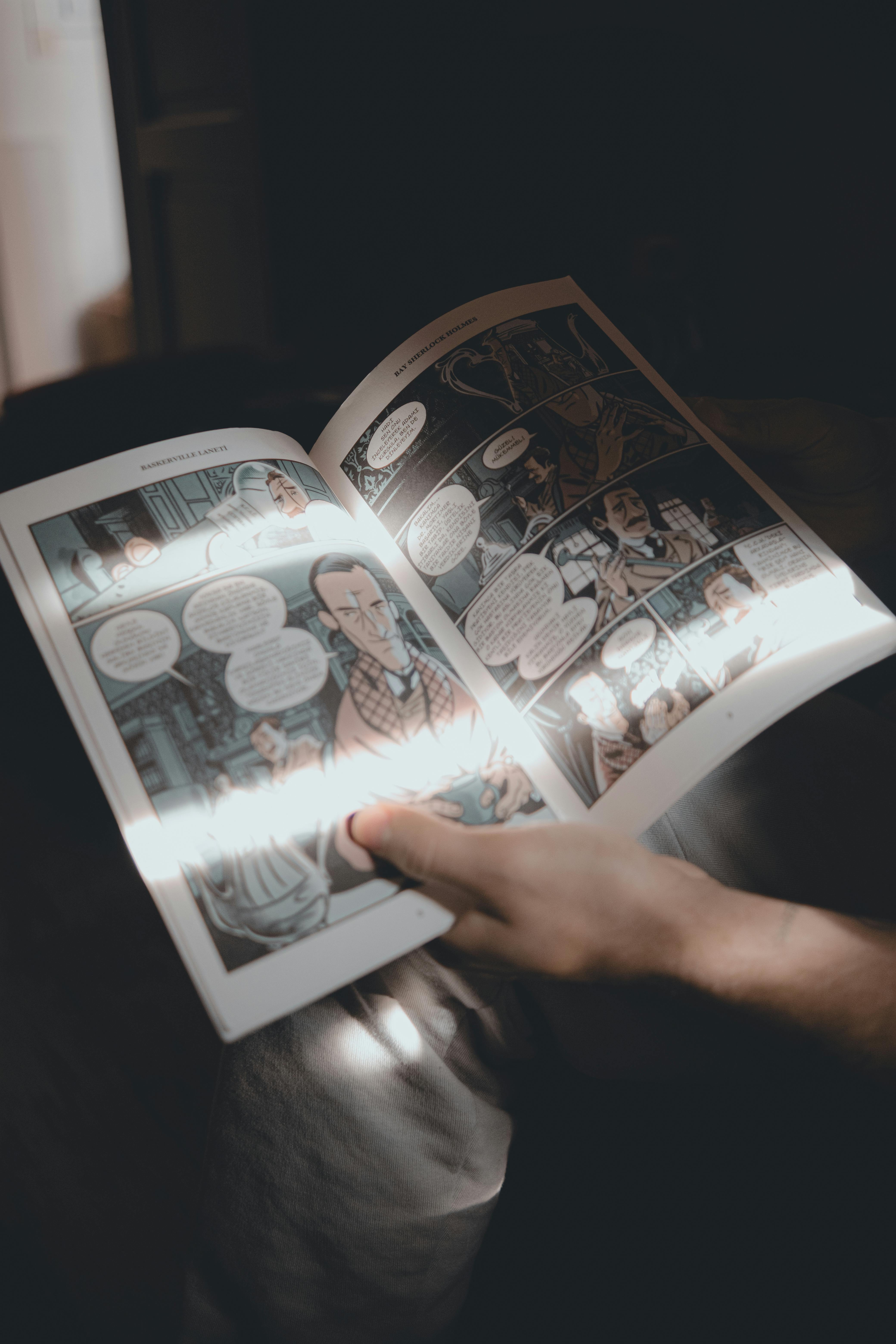 Hand Holding Comic Book in Soft Lighting