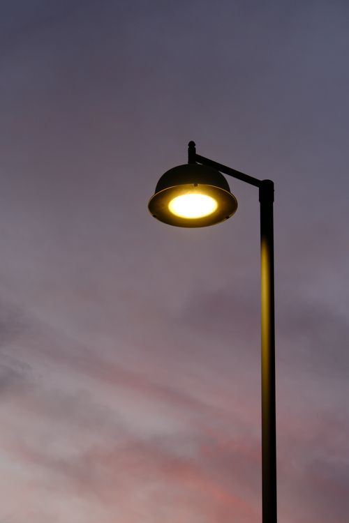 Free A glowing streetlamp against a vivid twilight sky creating an urban ambiance. Stock Photo