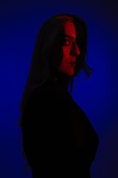 An artistic portrait of a woman with creative red and blue lighting creating a cinematic effect.