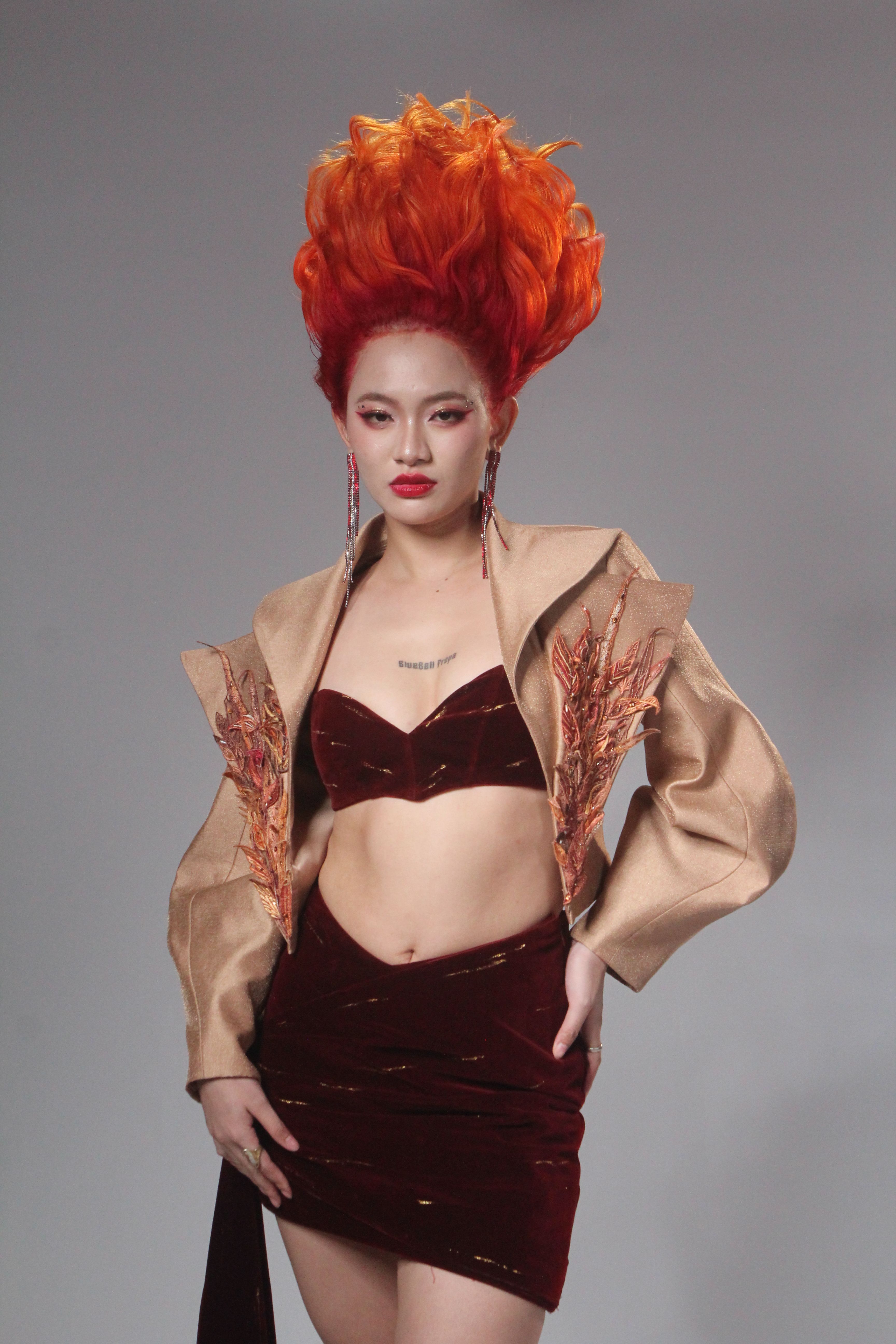 Bold fashion portrait featuring a woman with striking orange hair and stylish outfit.