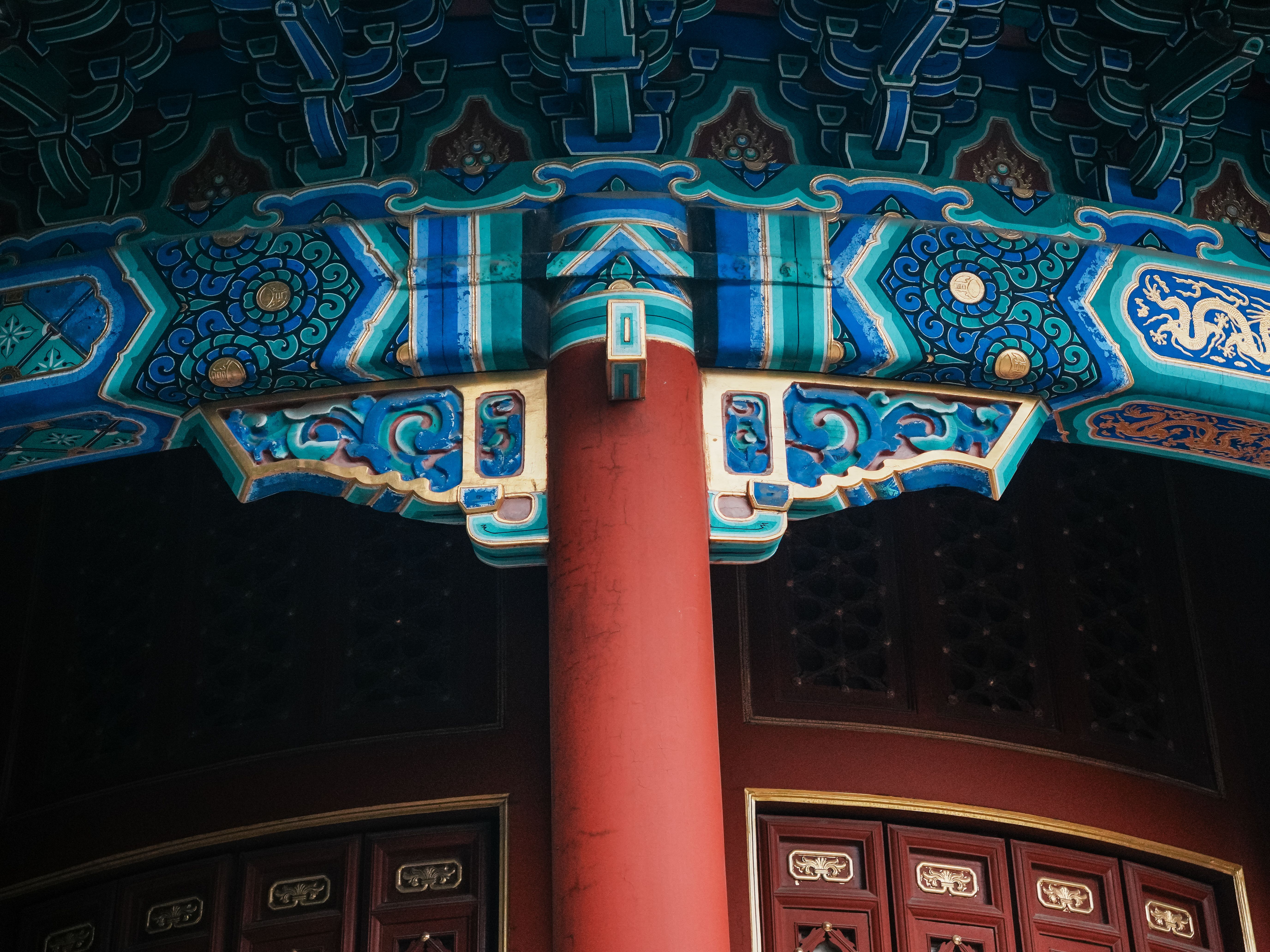A close-up of intricate dougong brackets under a temple eaves