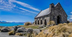 在明亮的蓝天下，历史悠久的特卡波湖石头教堂展现了新西兰的秀丽风景