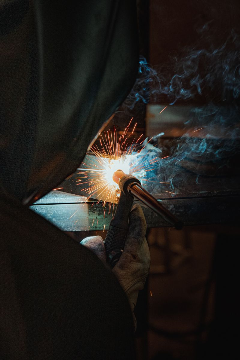 Close-up of a welder at work with sparks and smoke