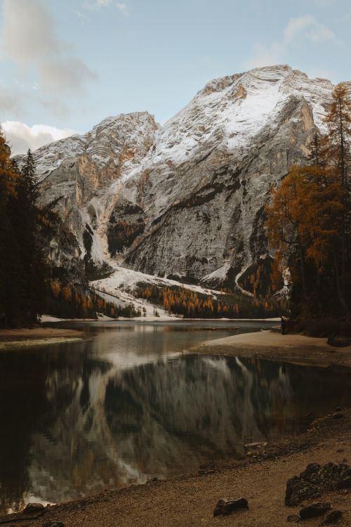 Free Stunning view of Lago di Braies reflecting the snow-capped Dolomites in autumn. Stock Photo