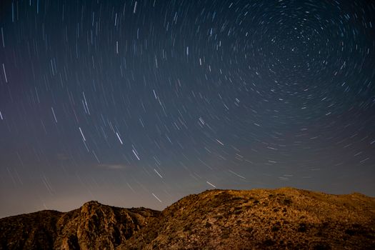 Long exposure of star trails over the desert landscape in Joshua Tree National Park, California.