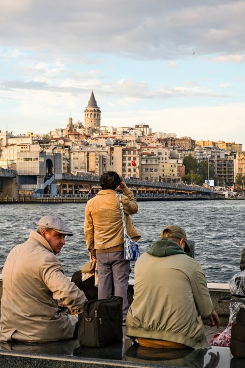 Free A group of people enjoys the view of Galata Tower from the waterfront in Istanbul, Türkiye. Stock Photo