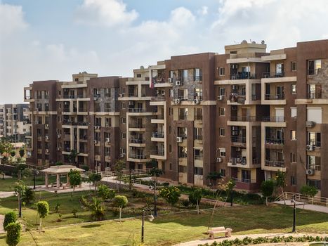 Contemporary apartment complex with spacious balconies overlooking a landscaped park area.