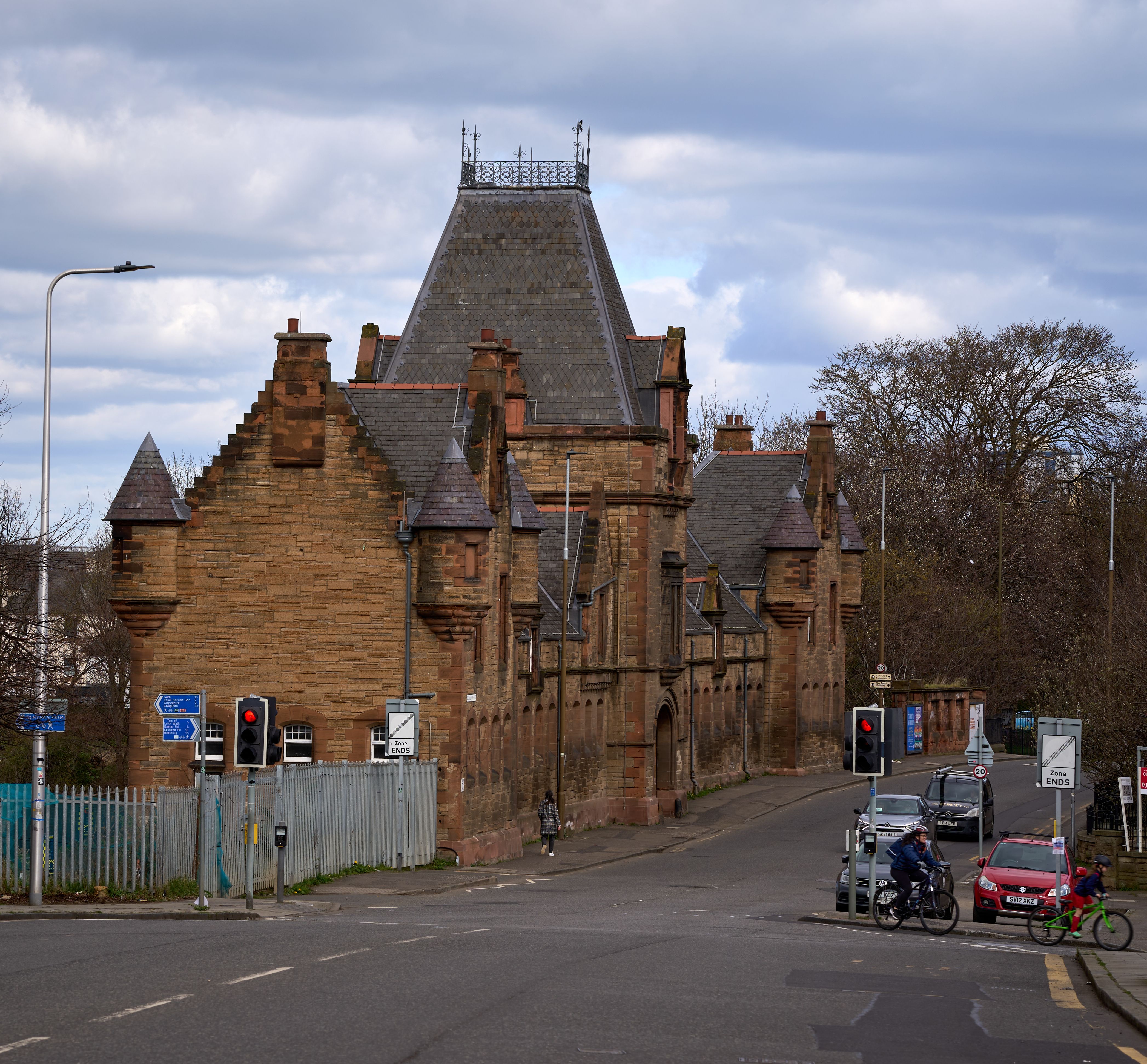 A classic stone building in Edinburgh, showcasing traditional architecture against a cloudy spring sky.