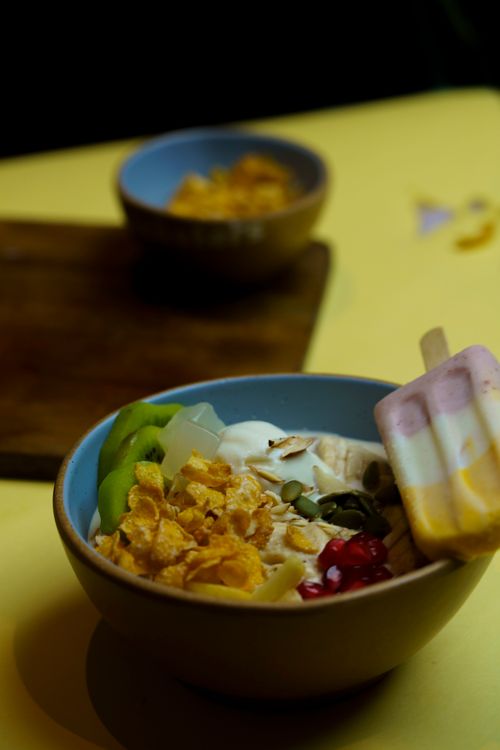 Free Bright and nutritious breakfast bowl featuring yogurt, nuts, fresh fruit, and cornflakes. Stock Photo