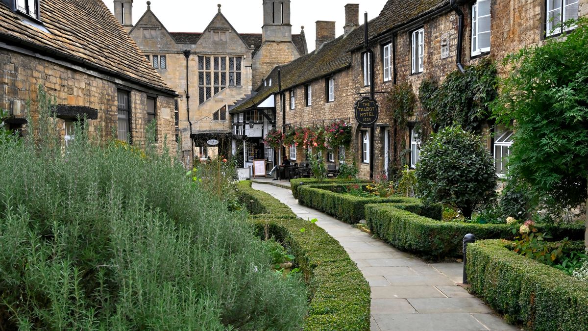 A Cotswold village street of honey-coloured stone cottages with a lavender border, a typical stop on a weekend away in the Cotswolds