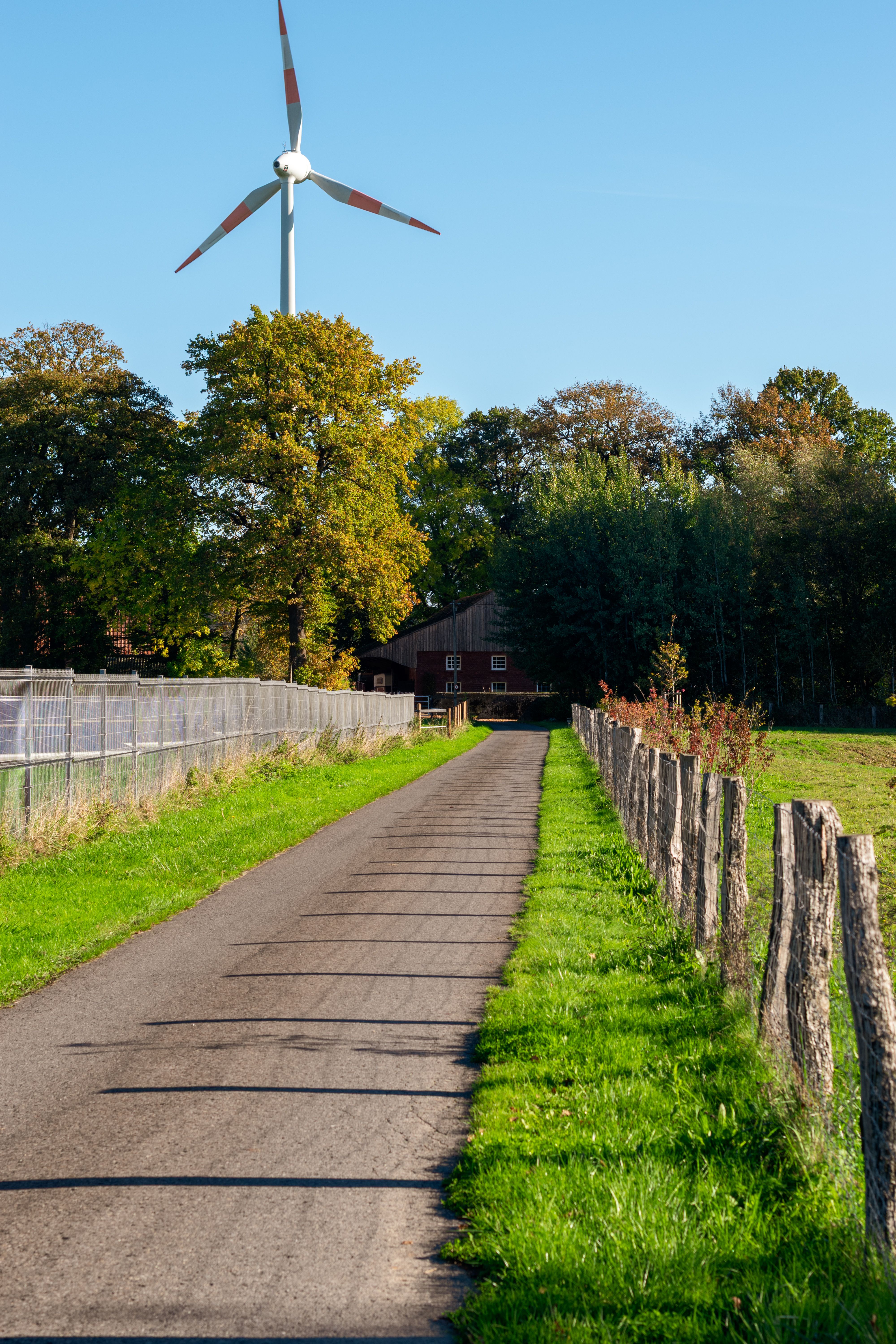Scenic Rural Pathway with Wind Turbine and Barn · Free Stock Photo