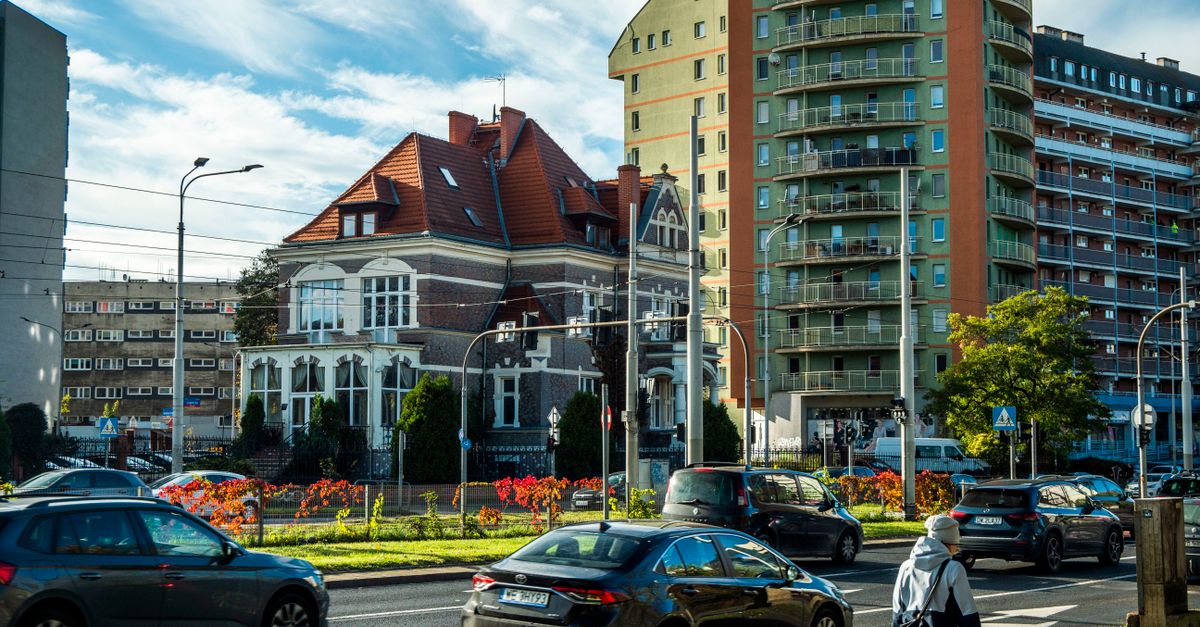 Busy city street with historic and modern buildings in autumn.