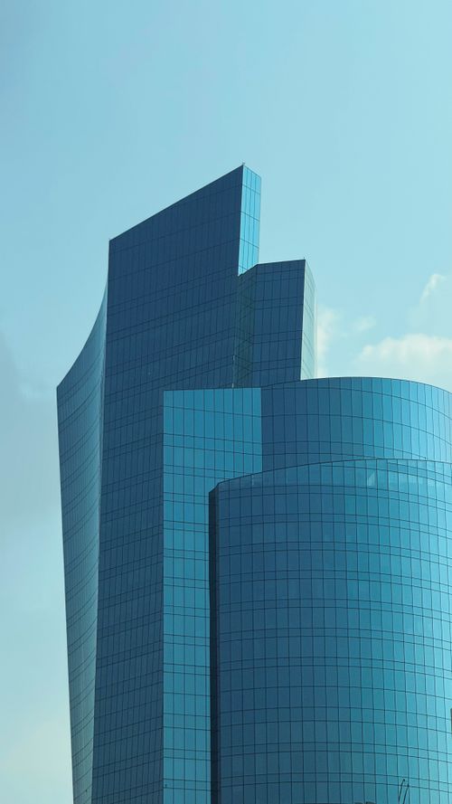 Free A striking view of sleek, modern skyscrapers in Abu Dhabi with reflective glass facades against a clear blue sky. Stock Photo