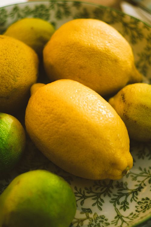 Free Close-up of vibrant lemons and limes on a decorative plate, highlighting fresh citrus fruits. Stock Photo