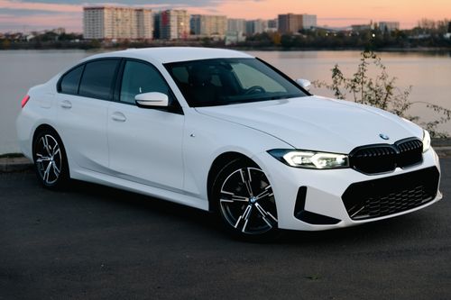 Free Elegant white sedan parked by a waterfront at sunset, reflecting modern automotive design. Stock Photo