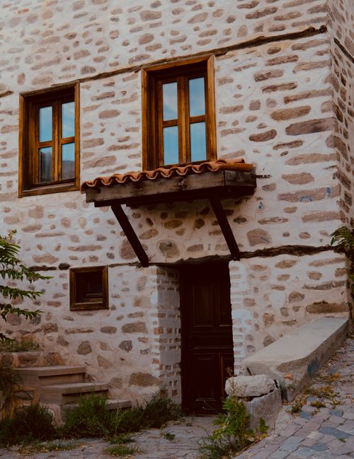 Free Charming rustic stone house with wooden windows and traditional architecture. Stock Photo