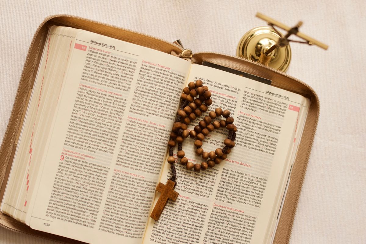 Biblie deschisa cu matanii de lemn si crucifix de alama
