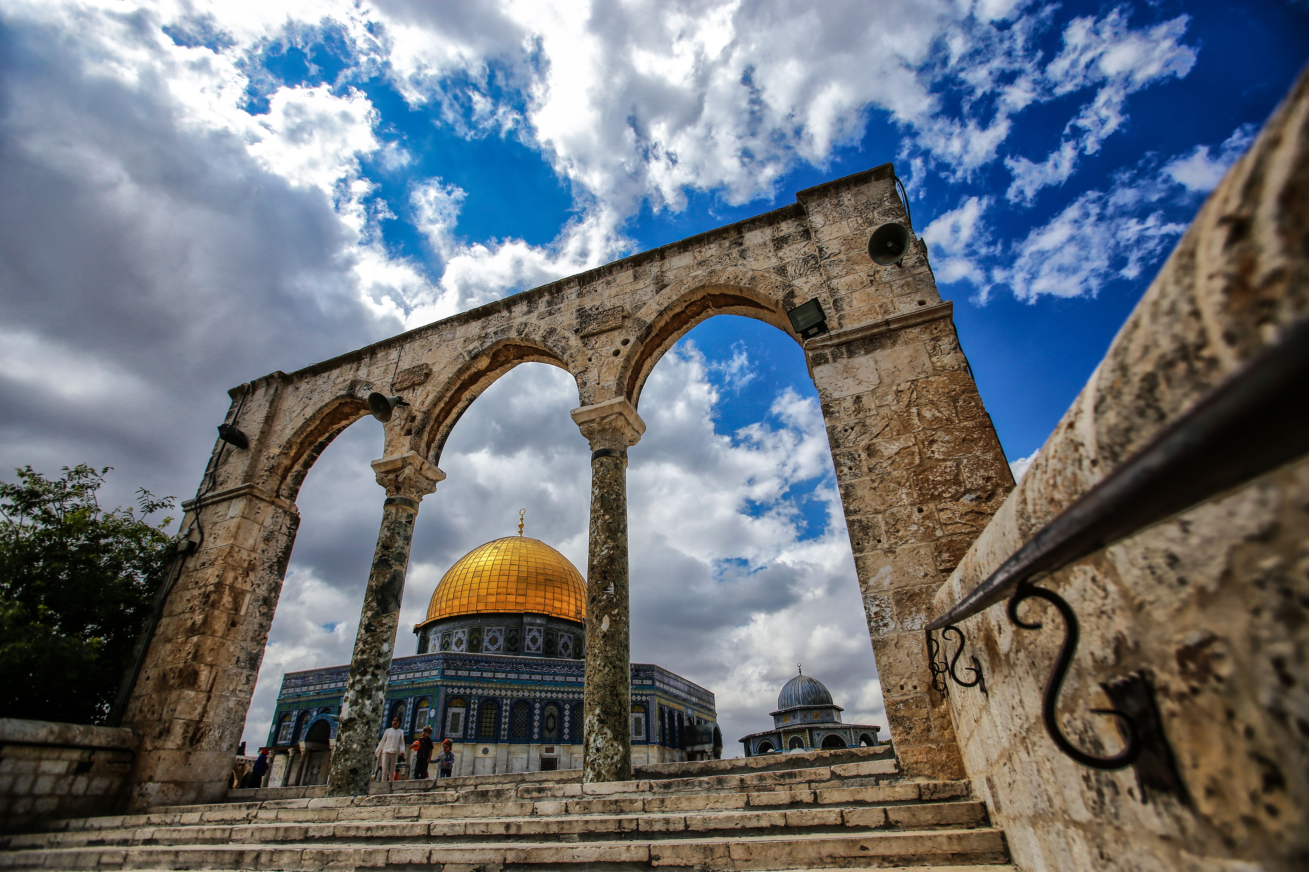 Stunning view of the Dome of the Rock in Jerusalem framed by ancient arches under a bright blue sky.. Photo by Mohamed Zarandah on Pexels