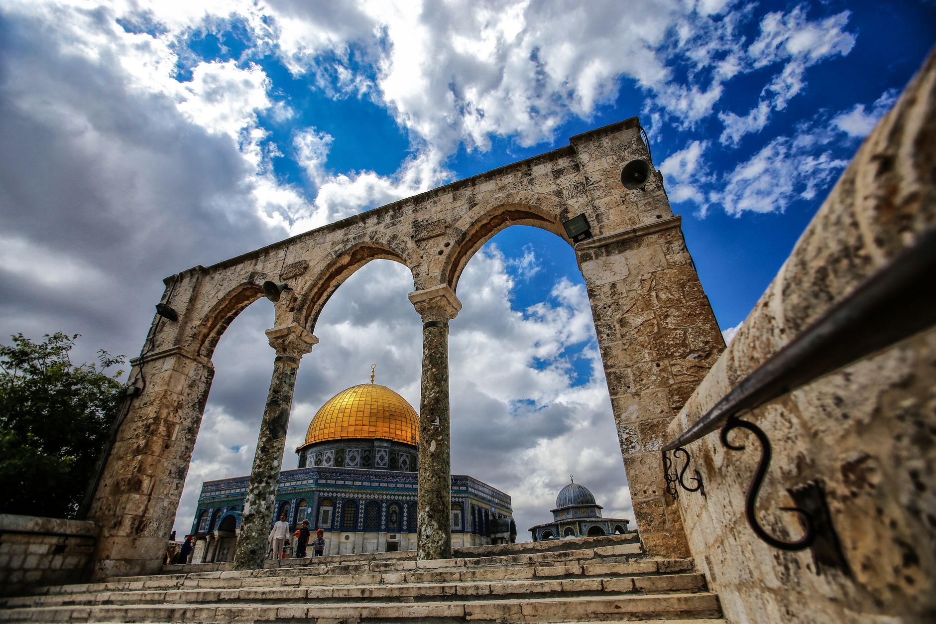 Stunning view of the Dome of the Rock in Jerusalem framed by ancient arches under a bright blue sky.. Photo by Mohamed Zarandah on Pexels