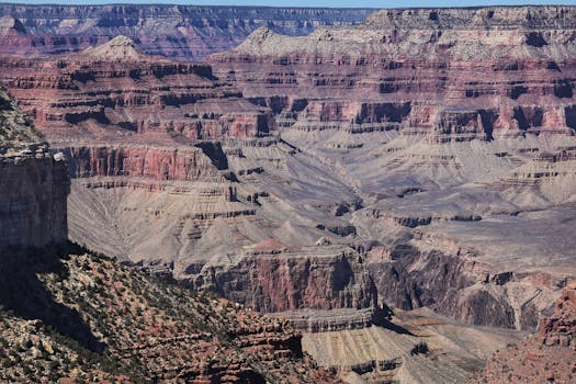 Stunning geological formations and vibrant layers of the Grand Canyon under a clear sky.