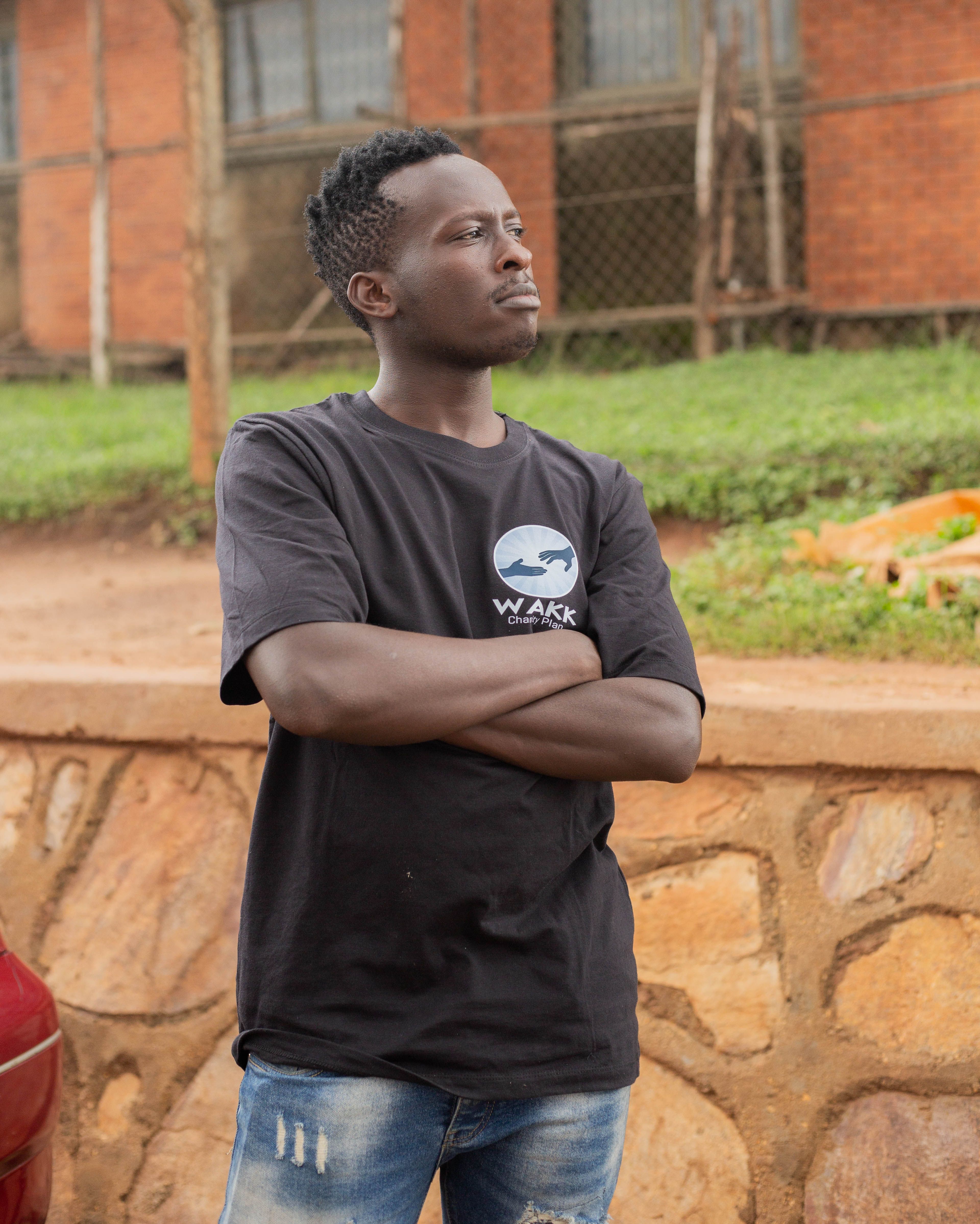 Young man standing confidently in a casual t-shirt and jeans outdoors with relaxed posture.