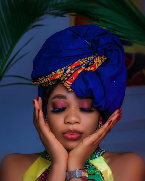 Free Portrait of a woman wearing colorful traditional African headwrap with closed eyes, exuding calm and elegance. Stock Photo