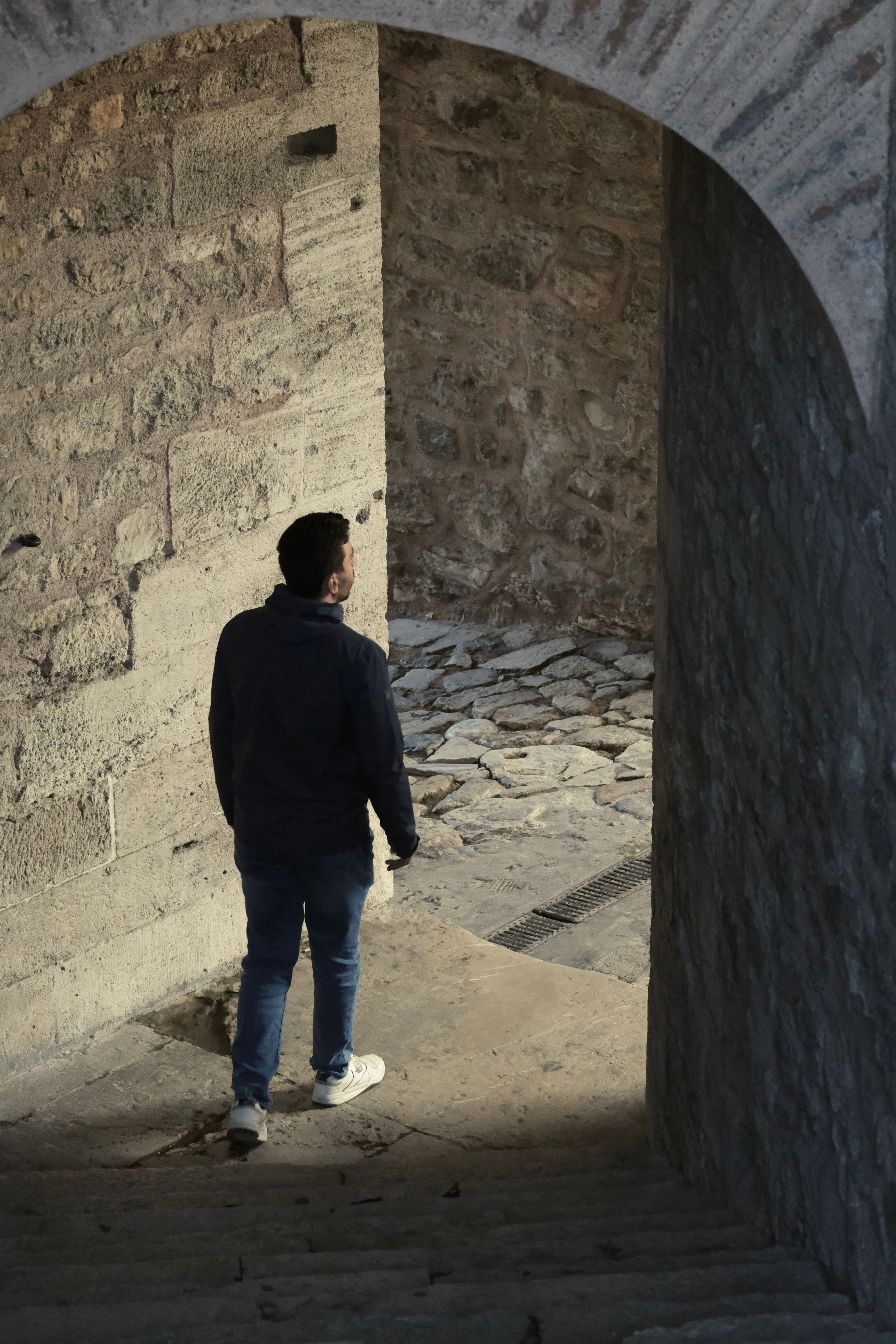 Man Walking Through Arched Stone Passageway in Istanbul · Free Stock Photo