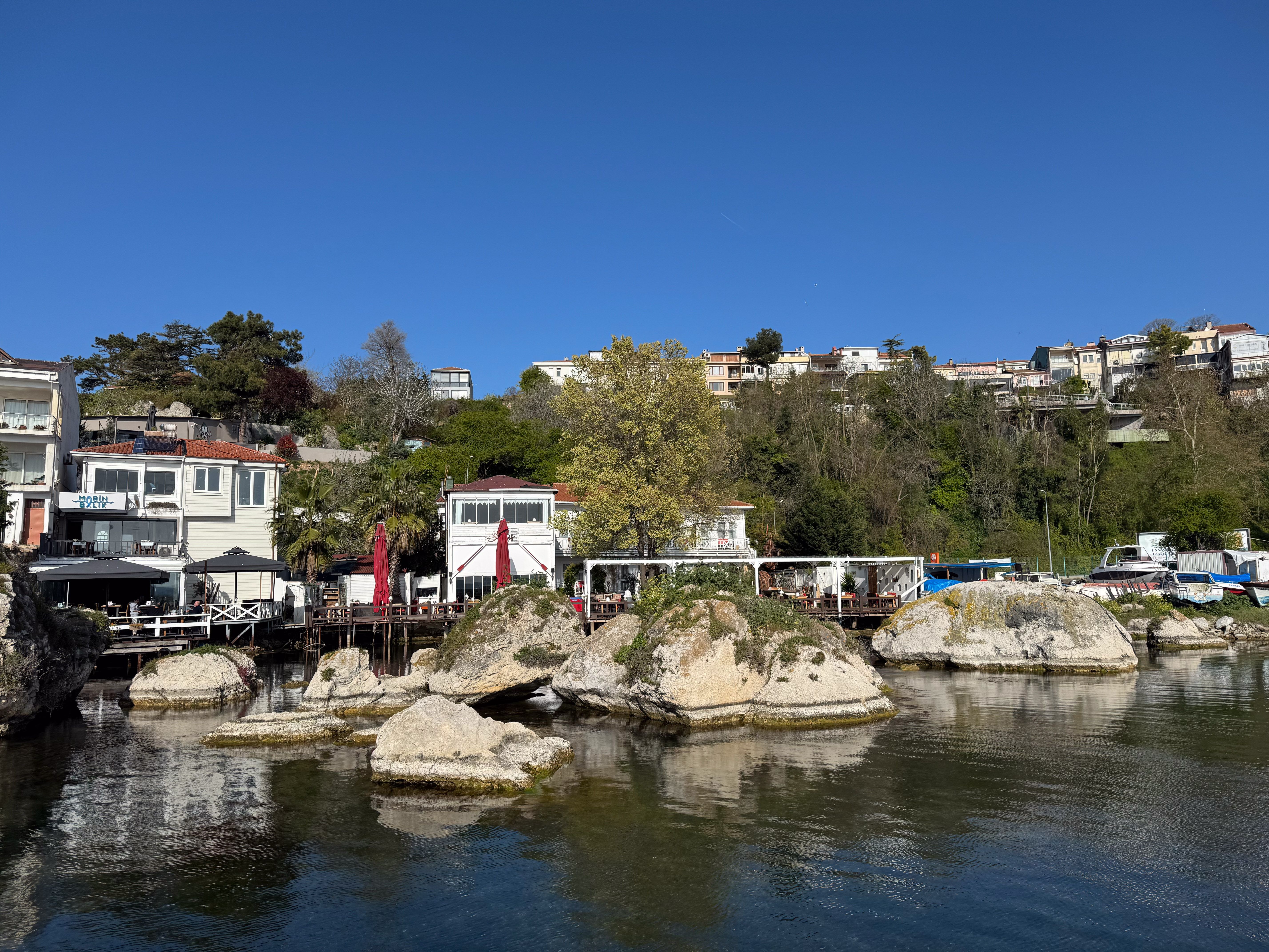 Scenic Coastal Village View with Waterside Rocks · Free Stock Photo