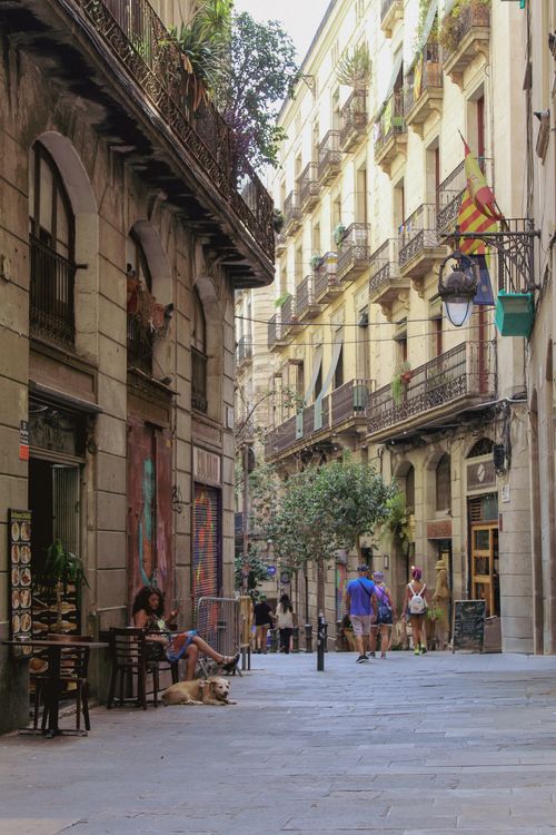 Free Lively street in Barcelona with people strolling and relaxing in a quaint setting. Stock Photo