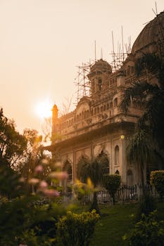 Sunset view of a scaffolded historic building in Lucknow, India showcasing Mughal architecture.