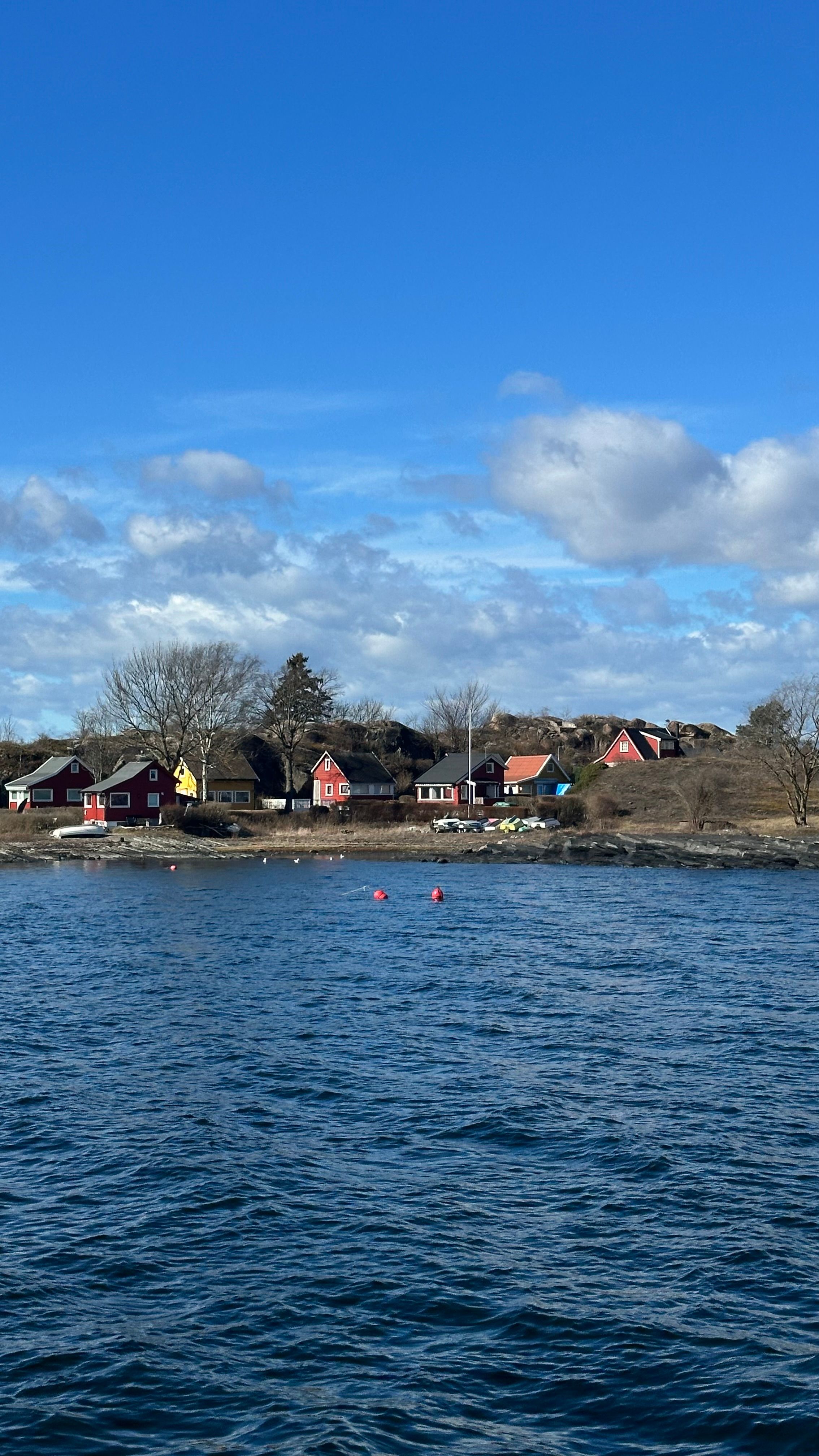Charming coastal village view with colorful houses under a bright blue sky.