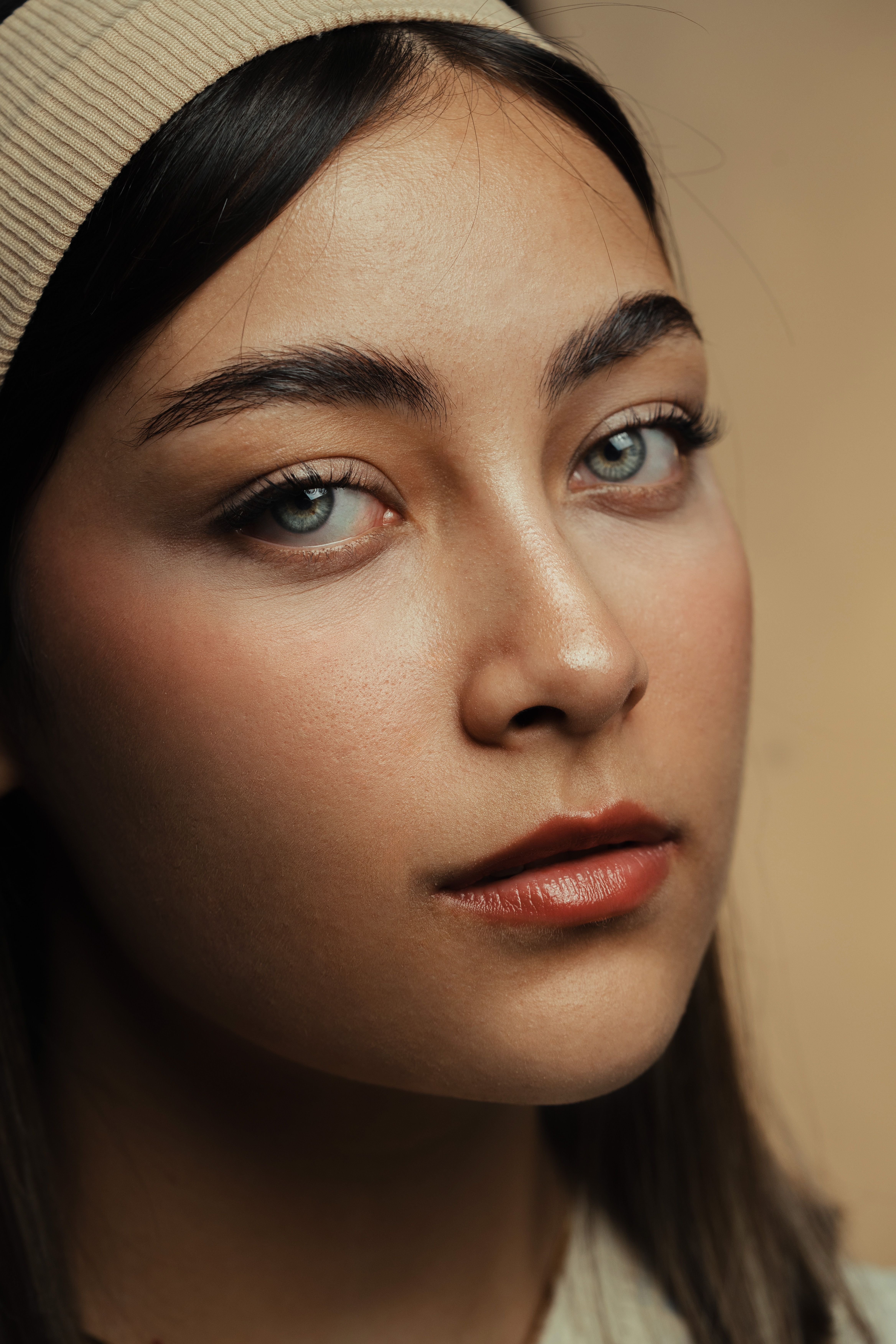 A close-up portrait of a woman with neutral makeup and serene expression.