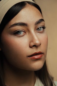 A close-up portrait of a woman with neutral makeup and serene expression.