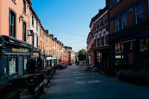 Photo by Adrien Olichon A picturesque urban street with colorful buildings under a clear blue sky.