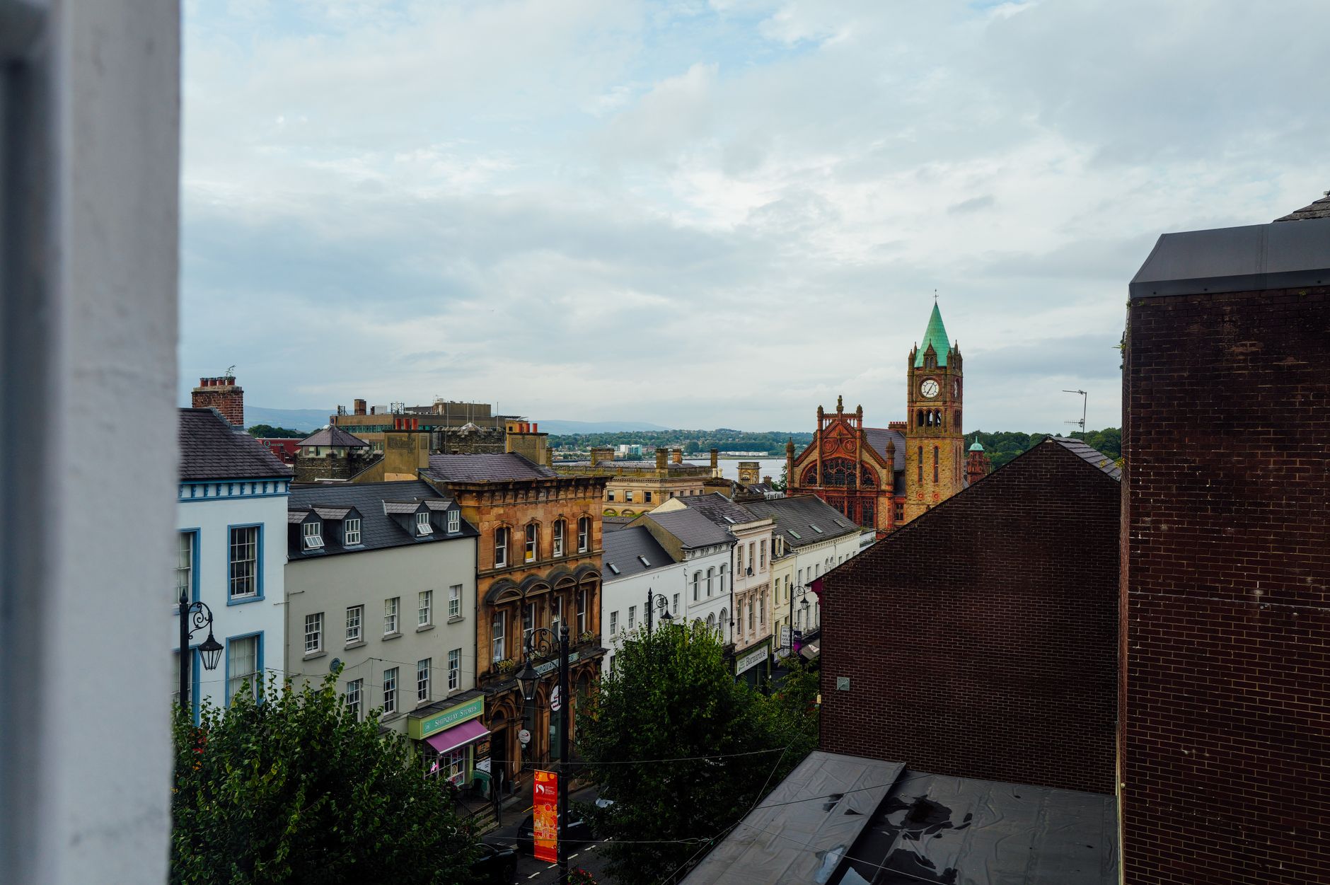 Scenic view of Derry cityscape highlighting historical buildings and the iconic Guildhall.