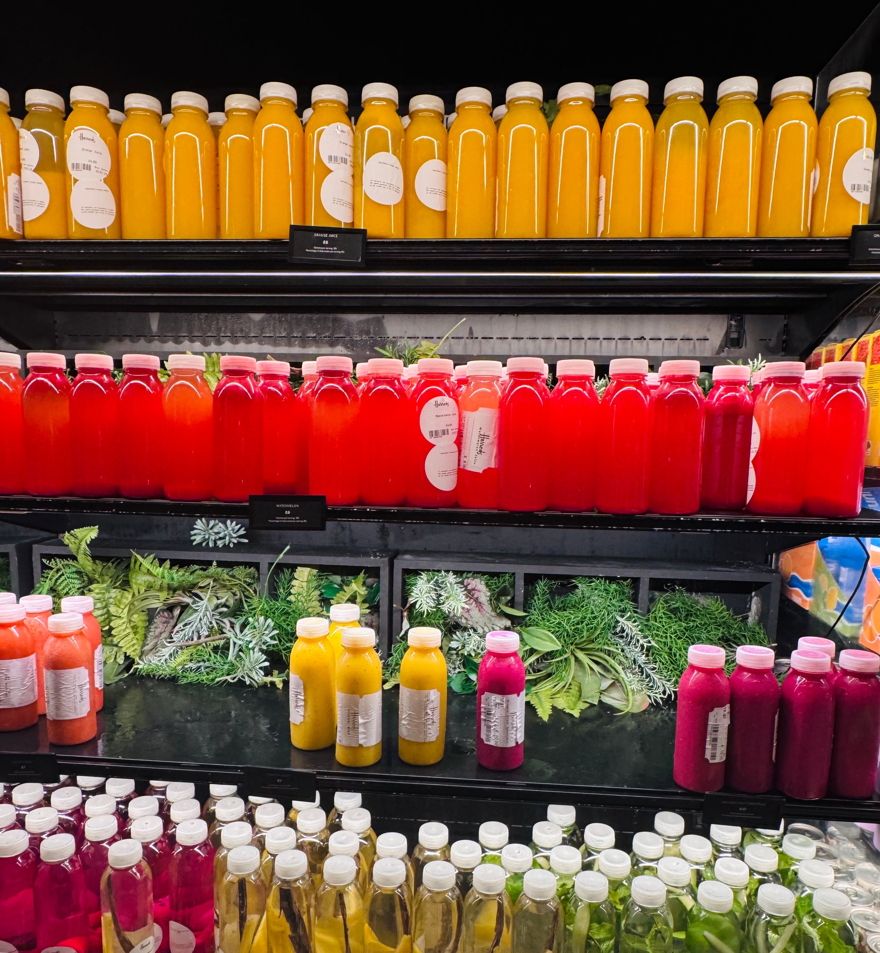 Colorful juice bottles on display, showcasing vibrant yellow and red hues.