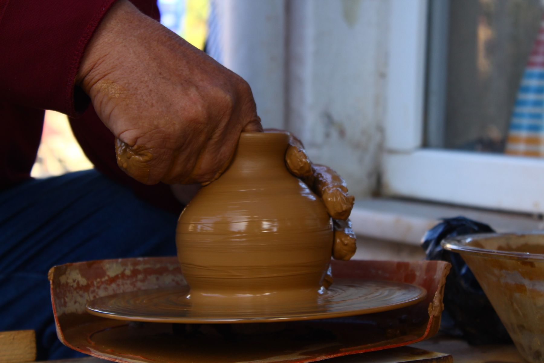 Artisan shaping clay on a pottery wheel