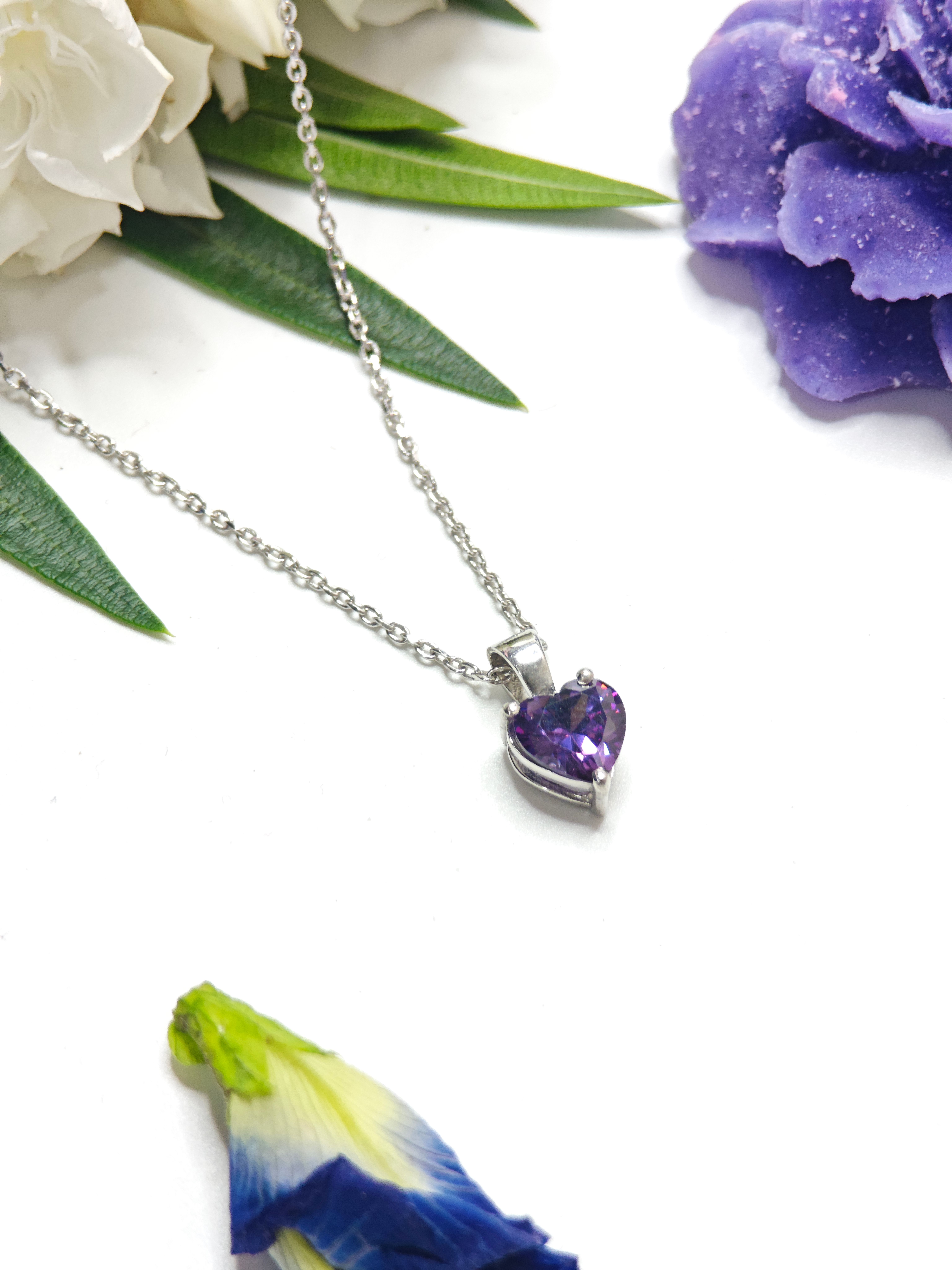 Silver necklace with a heart shaped purple gemstone pendant