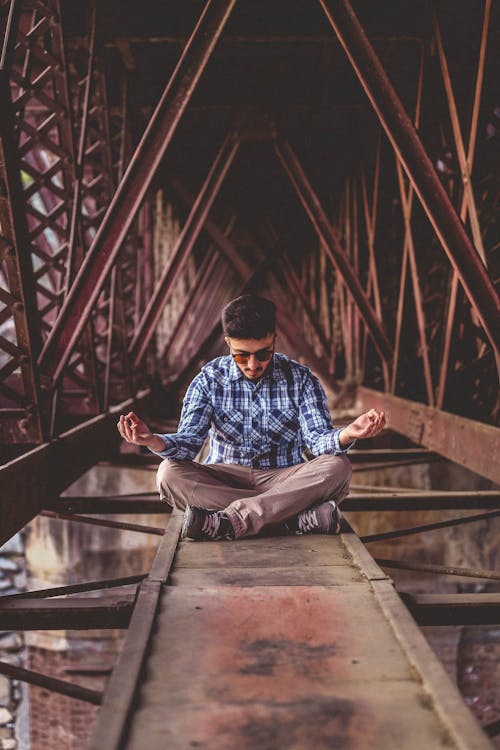 Free Man Meditating on Metal Surface Stock Photo