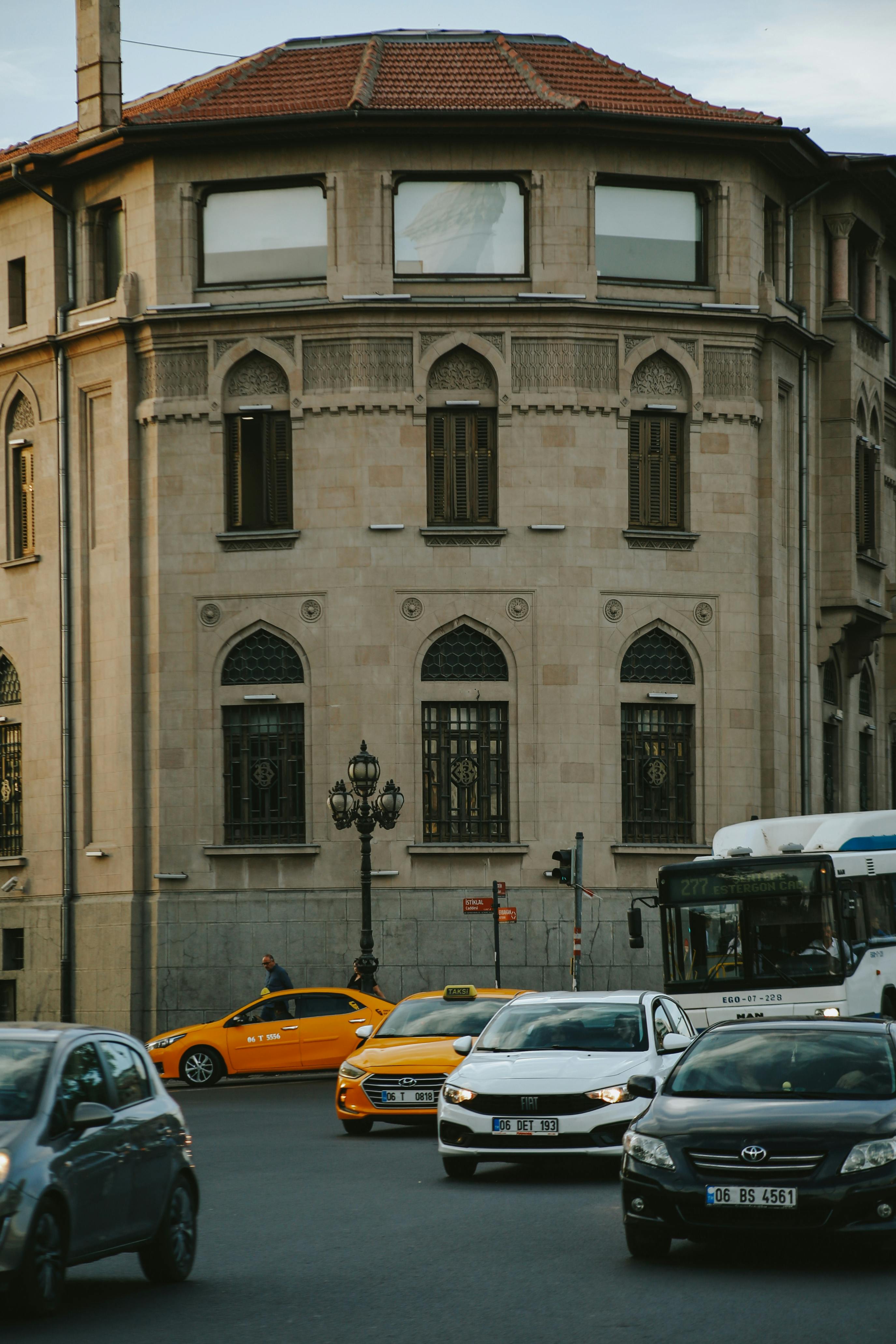 gratis Stadsverkeer passeert in de schemering een historisch gebouw, met auto's en een bus. Stockfoto